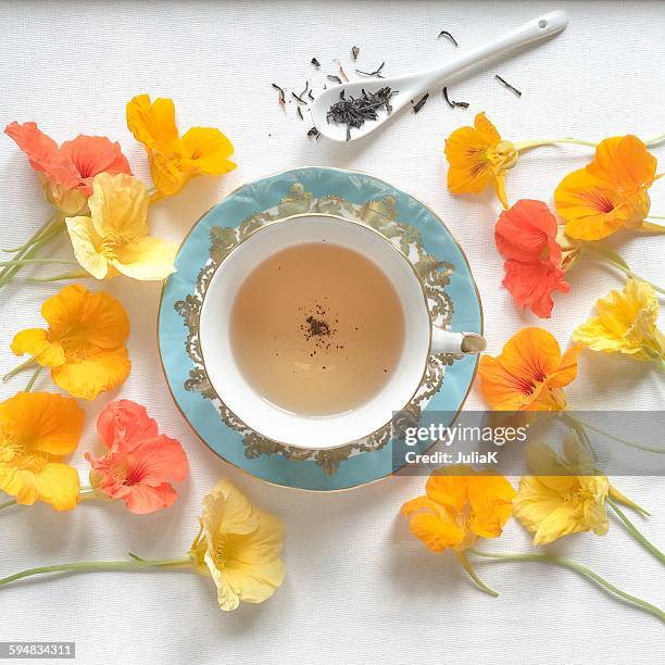 cup of tea surrounded by nasturtium flowers - cup of tea from above stock pictures, royalty-free photos & images