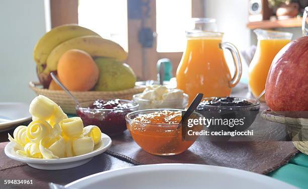 jams, fruit, juice and butter on breakfast table - ricciolo di burro foto e immagini stock