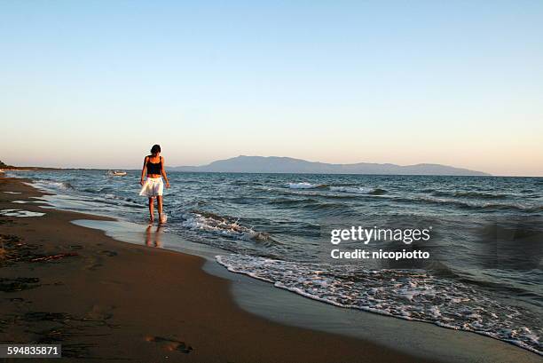 woman walking on the beach, orbetello, tuscany, italy - orbetello stock pictures, royalty-free photos & images