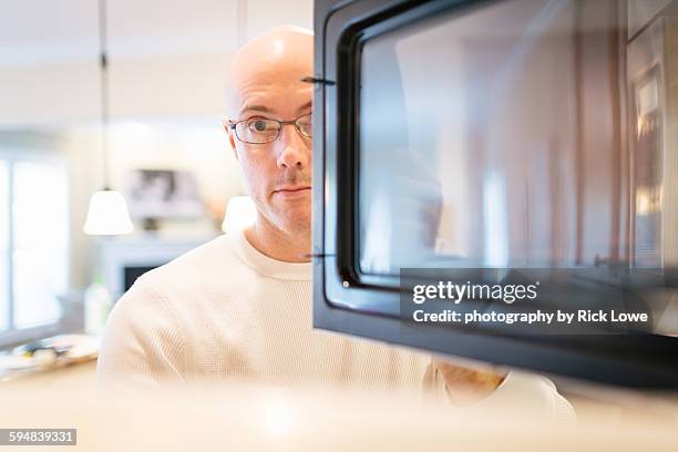 man looking into microwave - tv dinner stock pictures, royalty-free photos & images