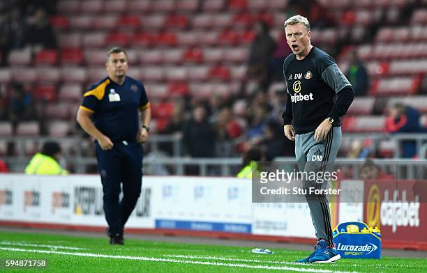 David Moyes, Manager of Sunderland gives instructions with Micky Mellon, Manager of Shrewsbury Town during the EFL Cup second round match between...