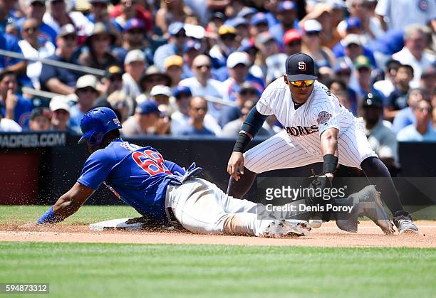 Jorge Soler of the Chicago Cubs slides into third base as Yangervis Solarte of the San Diego Padres loses the ball during the fourth inning of a...