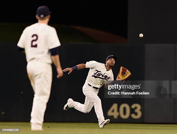 Brian Dozier of the Minnesota Twins looks on as teammate Eddie Rosario makes a catch in center field during the fourth inning of the game against the...