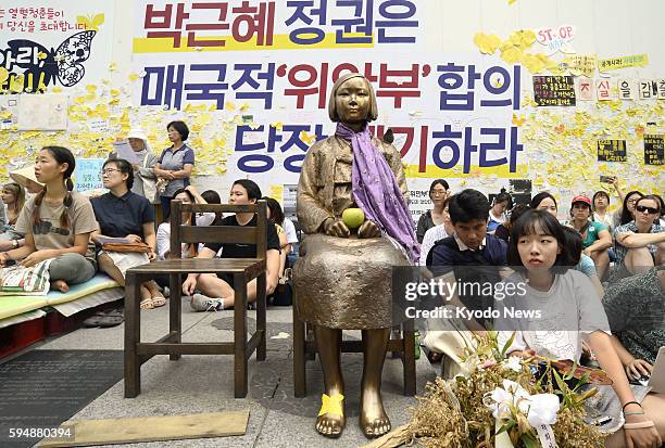 Activists gather around a statue of a girl in front of the Japanese Embassy in Seoul that symbolizes the so-called "comfort women" on Aug. 24 after...