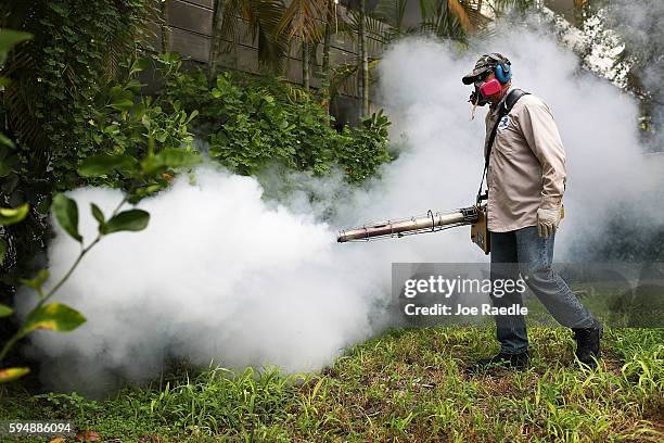 Carlos Varas, a Miami-Dade County mosquito control inspector, uses a Golden Eagle blower to spray pesticide to kill mosquitos in the Miami Beach...