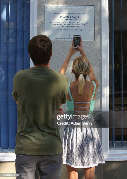 Visitor photographs a plaque for British musician David Bowie hanging on his former residence on August 24, 2016 in Berlin, Germany. Bowie, who died...