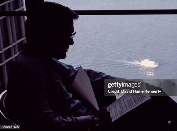 Former Secretary of Defense Donald Rumsfeld reads in his hotel room overlooking the Detroit River during the 1980 Republican National Convention,...