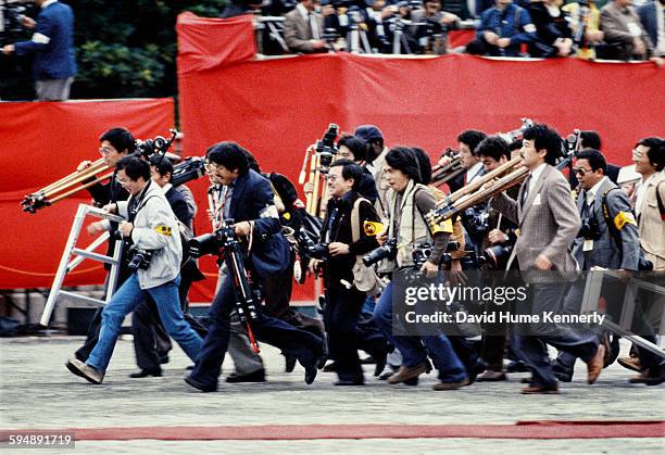Japanese cameramen run to their positions to cover U.S. President Ronald Reagan's arrival to greet Emperor Hirohito at the Akasaka Guest Palace,...