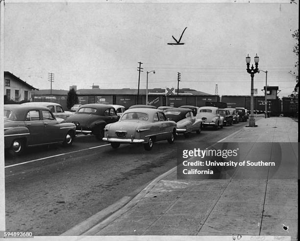 'Bottleneck,' Autos traveling east on Los Feliz Road in Glendale are held up while freight train passes, Glendale, California, July 29, 1957.