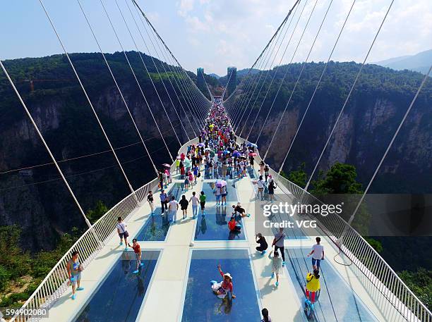 Aerial view photo shows tourists visiting on the glass-bottom bridge at Zhangjiajie Grand Canyon on August 20, 2016 in Zhangjiajie, Hunan Province of...