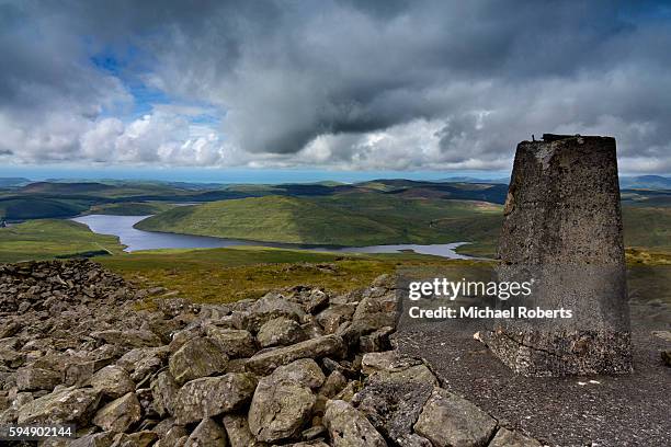 the trig point on the summit of plynlimon, or pen pumlumon fawr, overlooking nant-y-moch reservoir in the cambrian mountains, wales - monti cambriani foto e immagini stock