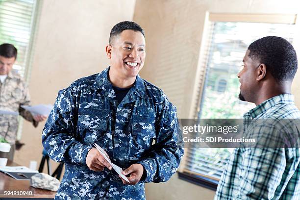 mature soldier talking to young man at military recruitment event - amerikanska flottan bildbanksfoton och bilder