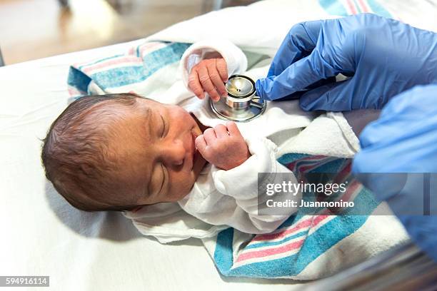 doctor checking a newborn (real people) - children's hospital stock pictures, royalty-free photos & images