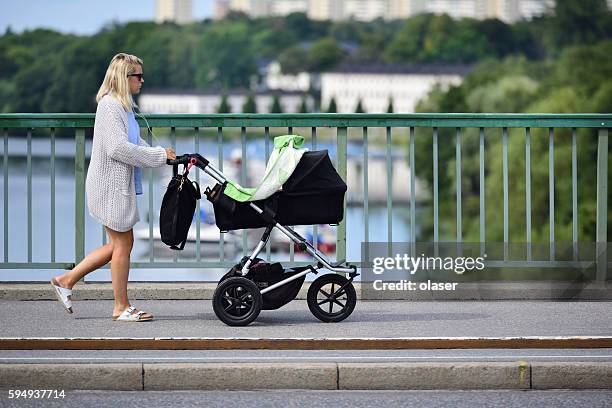 mother and child in stroller, on street/ bridge - jogging stroller stock pictures, royalty-free photos & images