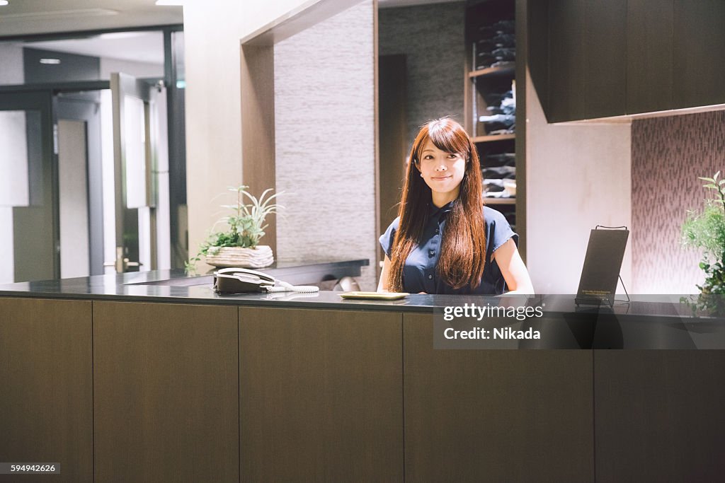 Business reception - woman standing greeting guests in lobby