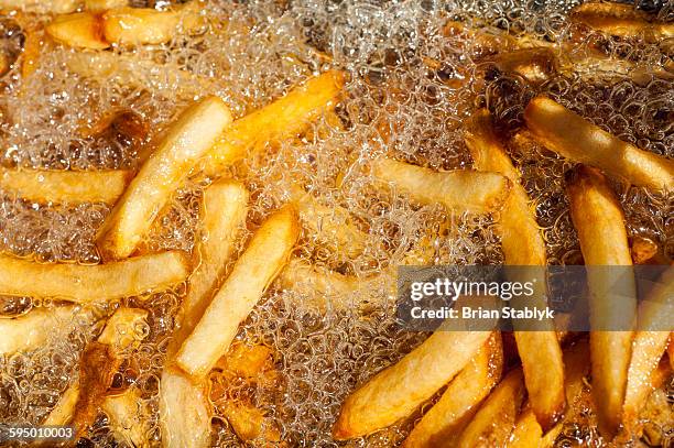 fast food french fries cooking in fryer - freidora fotografías e imágenes de stock