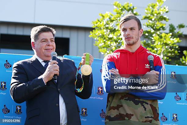 Australian Olympic gold medallist Kyle Chalmers stands with school principal Kevin Richardson to show his gold medal to students at Immanuel College...