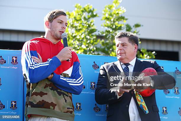 Australian Olympic gold medallist Kyle Chalmers stands with school principal Kevin Richardson to show his gold medal to students at Immanuel College...