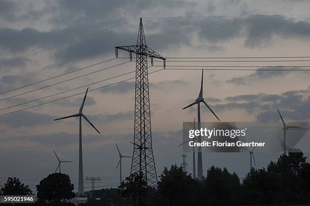 Wind turbines and power poles are captured on August 24, 2016 in Wustermark, Germany.