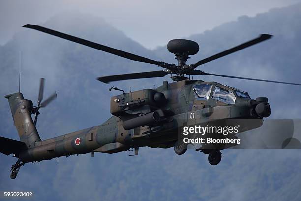 Japan Ground Self-Defense Force AH-64D Apache Longbow attack helicopter flies during a live fire exercise at the foot of Mount Fuji in the Hataoka...