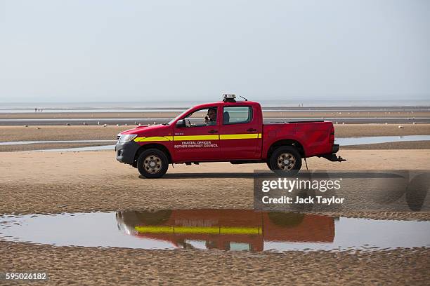 Coastal officers drive along Camber Sands on August 25, 2016 in Rye, England. Five men were found dead after being pulled from the sea on the hottest...