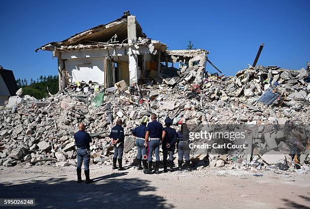 Police officers view the remains of a building that was destroyed during an earthquake, on August 25, 2016 in Amatrice, Italy. The death toll in the...