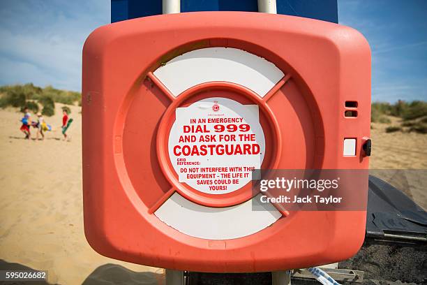 Sign which reads "In an emergency dial 999 and ask for the coastguard" is displayed on a lifebuoy on Camber Sands on August 25, 2016 in Rye, England....