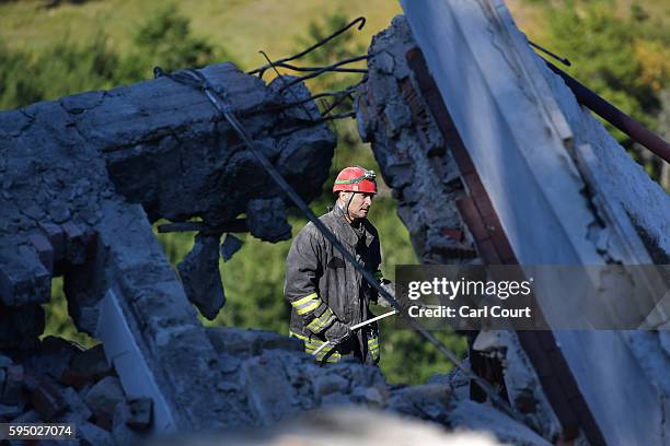 Emergency workers search the rubble of a building that was destroyed during an earthquake, on August 25, 2016 in Amatrice, Italy. The death toll in...