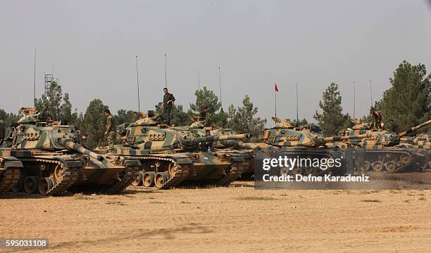 Turkish soldiers stand on tanks as they prepare for a military operation at the Syrian border town of Karkamis in the southern region of Gaziantep,...