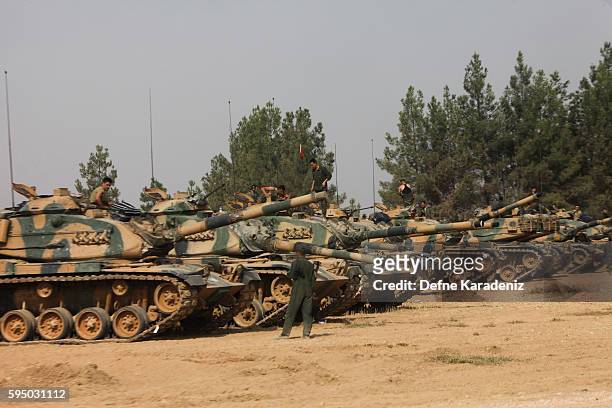 Turkish soldiers stand on tanks as they prepare for a military operation at the Syrian border town of Karkamis in the southern region of Gaziantep,...