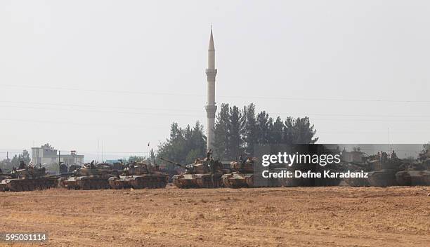 Turkish soldiers stand on tanks as they prepare for a military operation at the Syrian border town of Karkamis in the southern region of Gaziantep,...