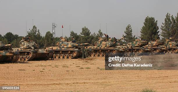 Turkish soldiers stand on tanks as they prepare for a military operation at the Syrian border town of Karkamis in the southern region of Gaziantep,...