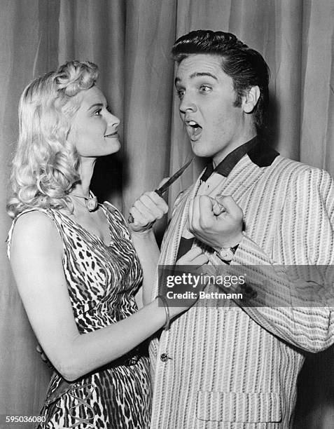 Actress Irish McCalla playfully threatens Elvis Presley with a knife while on The Milton Berle Show.