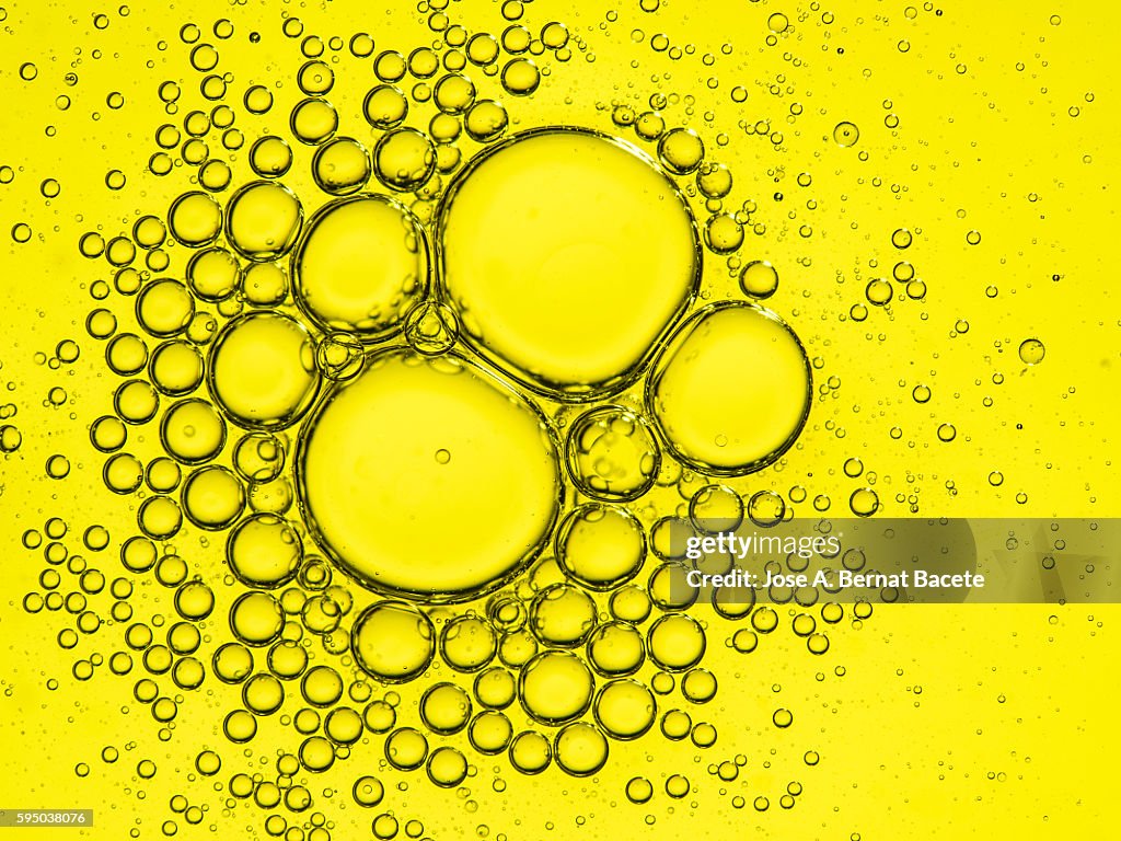 Full Frame of circular bubbles floating on water yellow