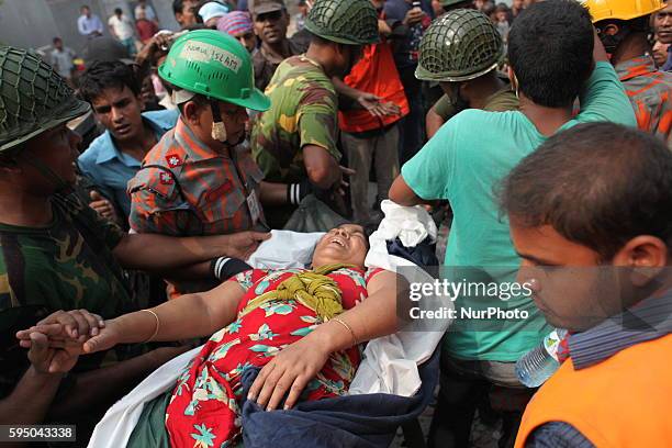 In this photograph taken on April 25 Civilians rescue an injured garment worker during a rescue operation after the eight-storey building Rana Plaza...