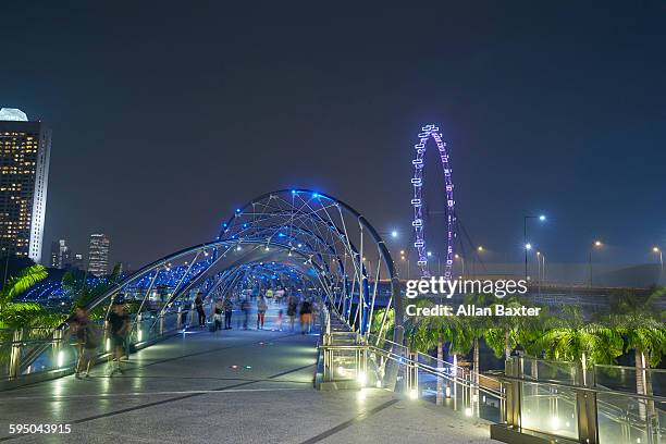 the high tech helix bridge at night - singapore flyer stock-fotos und bilder