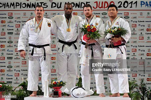 Andreas Toelzer of Germany with the silver medal, five-time world champion Teddy Riner of France with the gold medal, Alexander Mikhaylin of Russia...