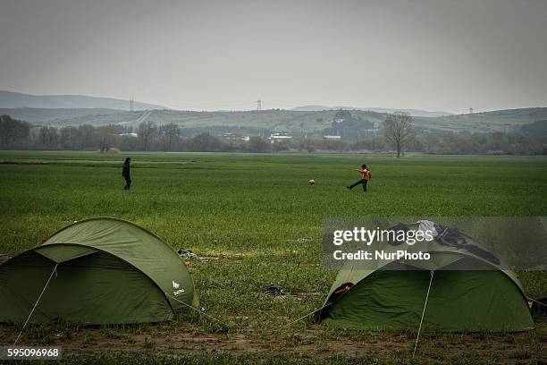 Migrants play football at makeshift camp at the Greek-Macedonian border, near the Greek village of Idomeni, on March 16 where thousands of refugees...