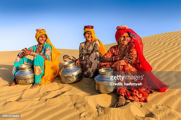 indische frauen tragen von wasser aus der gut, wüste dorf, indien - rajasthani women stock-fotos und bilder