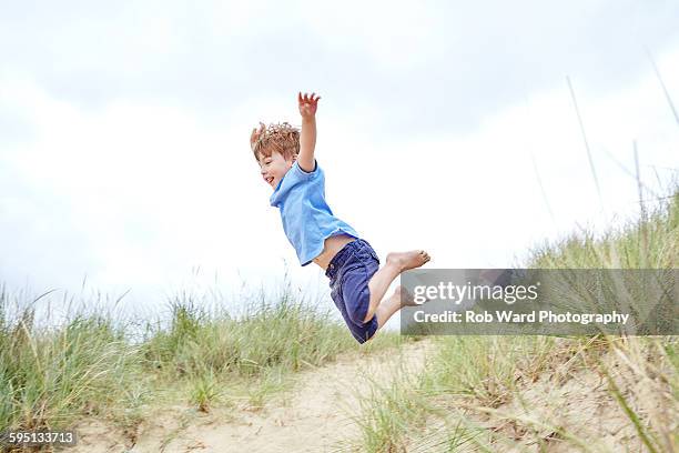 boy jumping from a sand dune - leap of faith modo di dire inglese foto e immagini stock