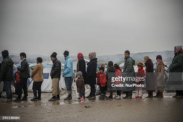 Refugees queue for food at makeshift camp at the Greek-Macedonian border, near the Greek village of Idomeni, on March 16 where thousands of refugees...