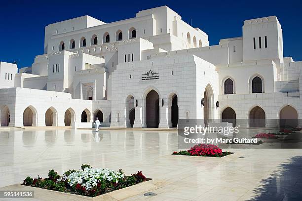 Man walking in front of the Royal Opera House in Muscat, Oman