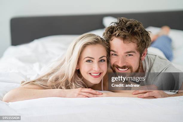 loving couple lying in bed - mattress stock pictures, royalty-free photos & images