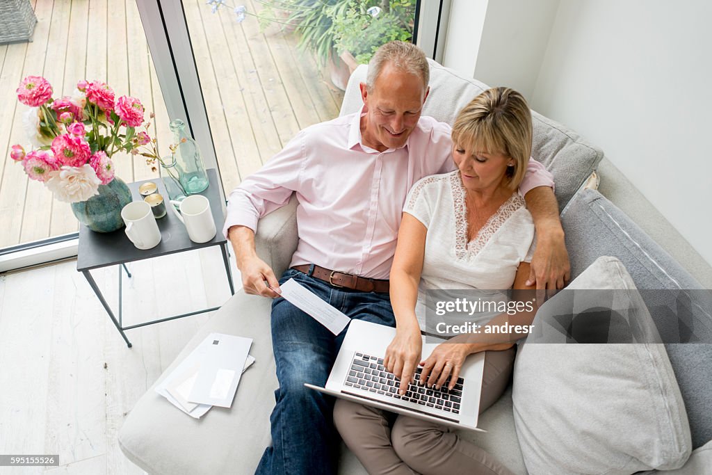 Senior couple paying bills online at home