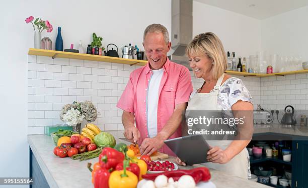 couple cooking at home following an online recipe - following recipe stock pictures, royalty-free photos & images