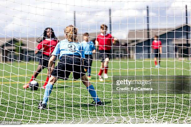 mixed gender soccer team makes a goal attempt - girl goalie stock pictures, royalty-free photos & images