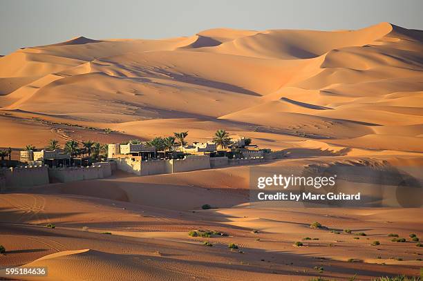 sunrise at the qasr al-sarab desert resort near liwa, united arab emirates. the luxury resort is nestled in the dunes of the empty quarter - a part of the arabian desert which covers much of the peninsula. - abu dhabi sunrise stock pictures, royalty-free photos & images