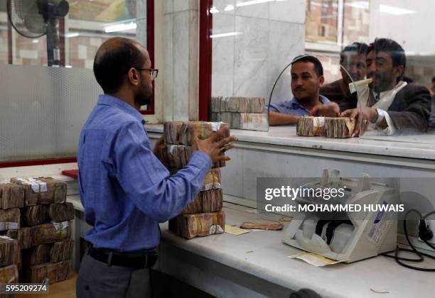 Bank customers withdraw Yemeni currency at the Central Bank of Yemen in the capital Sanaa on August 25, 2016.