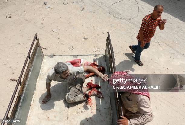 Graphic content / A wounded Syrian man sits in the back of a truck next to a dead girl following a barrel bomb attack on the Bab al-Nairab...