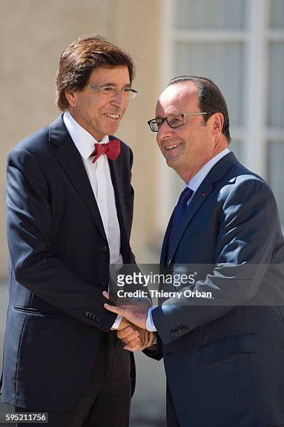 President of the Belgian Socialist party Elio Di Rupo is greeted by French president Francois Hollande after arriving for a meeting with European...